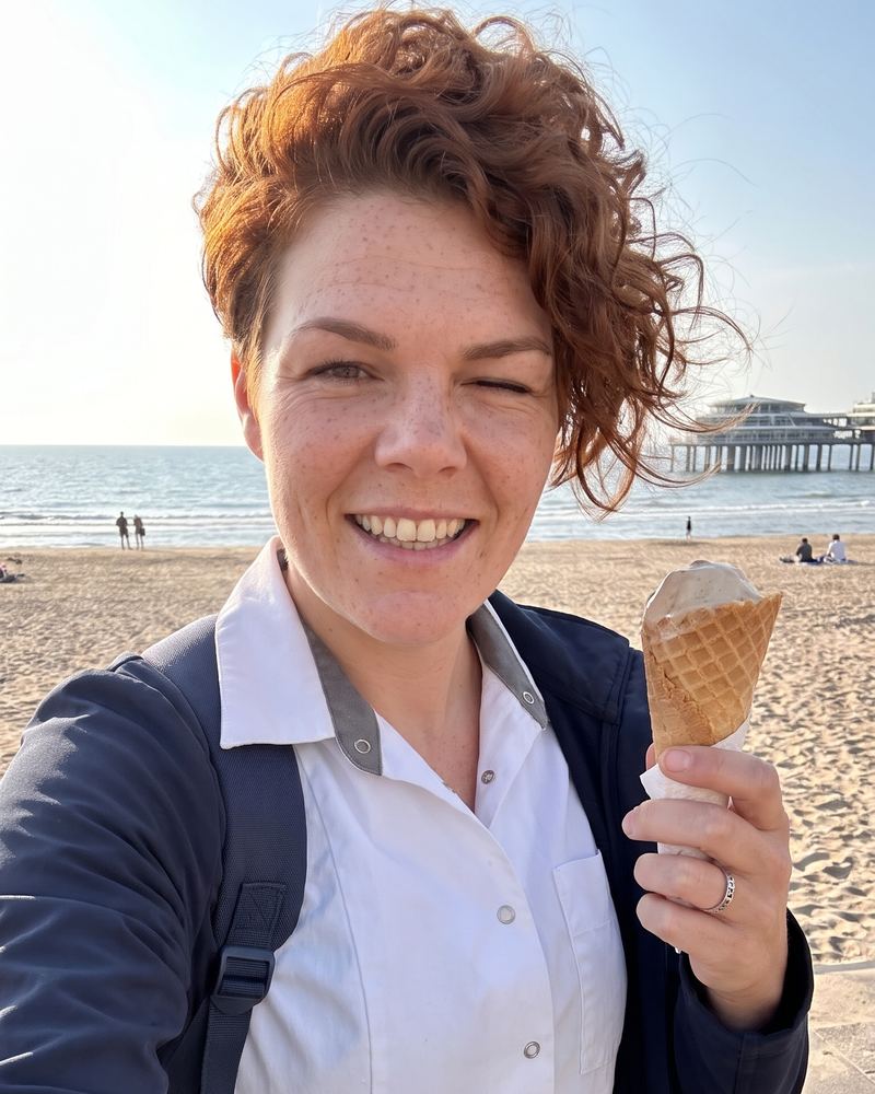 Zorgmedewerker met een ijsje op het strand van Scheveningen